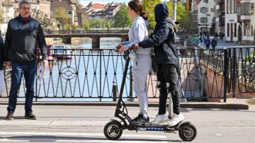 Dos personas montando un patinete el&eacute;ctrico.