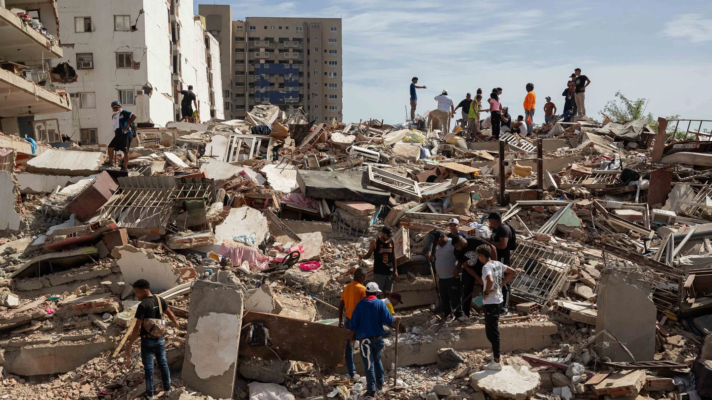 Personas caminan entre escombros de edificios afectado por terremotos este jueves, en Catia La Mar (Venezuela). Personas caminan entre escombros de edificios afectado por terremotos este jueves, en Catia La Mar (Venezuela).