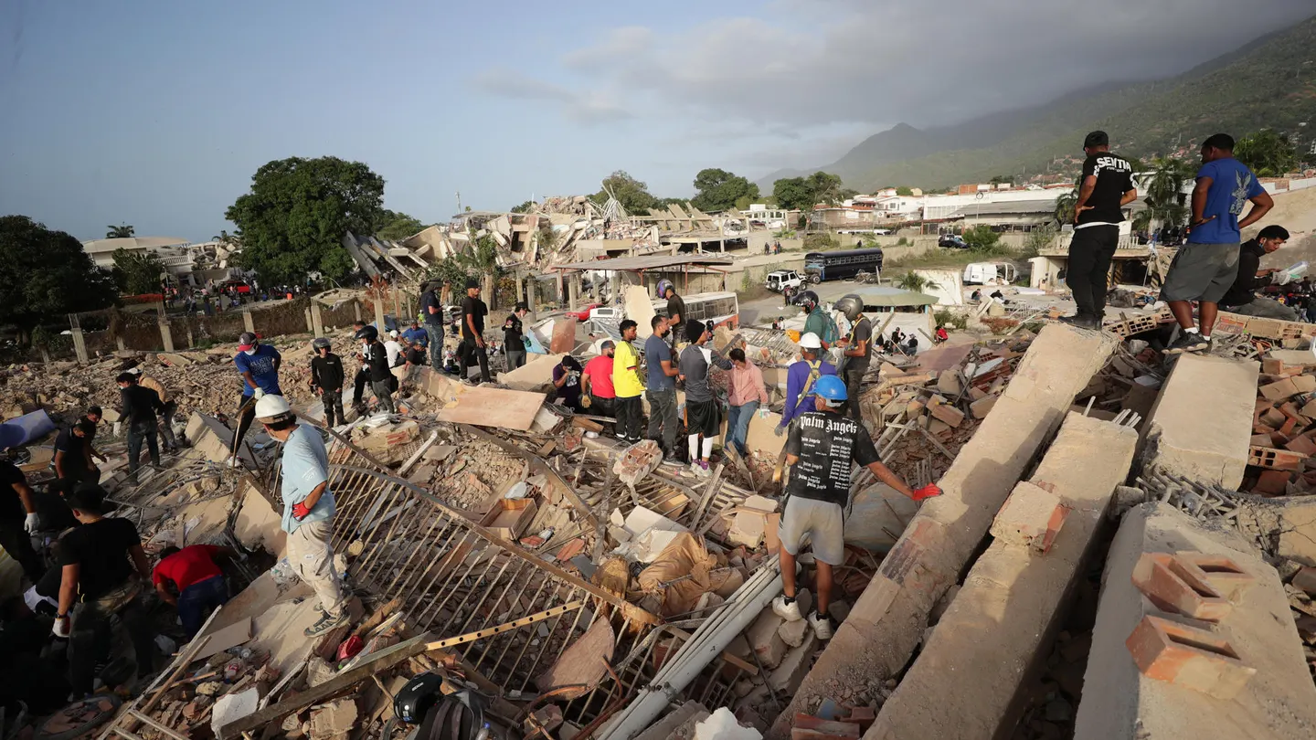 Personas realizan labores de búsqueda en una zona afectada por un terremoto en Venezuela Personas realizan labores de búsqueda en una zona afectada por un terremoto en Venezuela