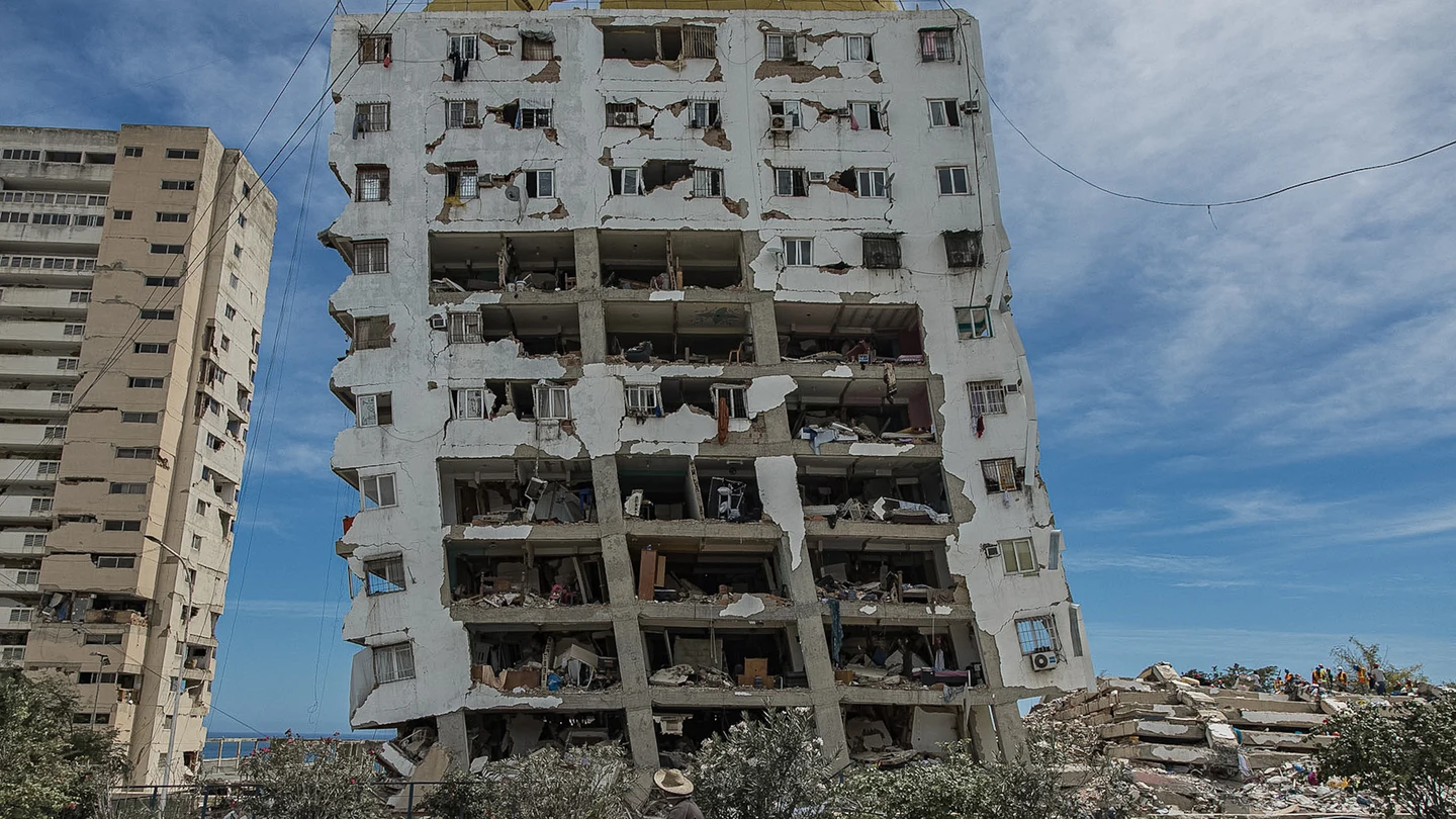 Una persona transita frente a un edificio destruido por los terremotos, este domingo, en Catia La Mar (Venezuela). Una persona transita frente a un edificio destruido por los terremotos, este domingo, en Catia La Mar (Venezuela).