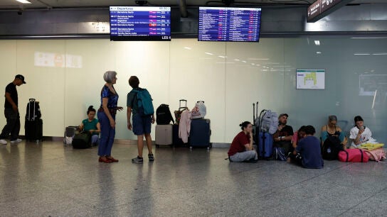 Un grupo de pasajeros espera este lunes a que salga su tren en la estaci&oacute;n de Atocha durante la huelga de dos d&iacute;as