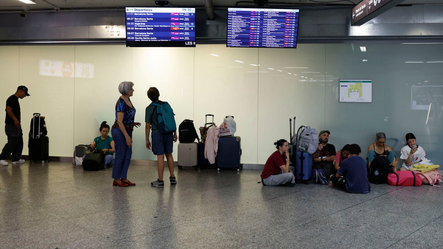 Un grupo de pasajeros espera este lunes a que salga su tren en la estaci&oacute;n de Atocha durante la huelga de dos d&iacute;as
