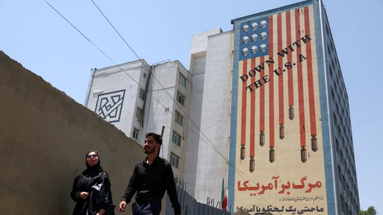 Personas caminan cerca de un mural anti-estadounidense en Teherán, Irán Personas caminan cerca de un mural anti-estadounidense en Teherán, Irán