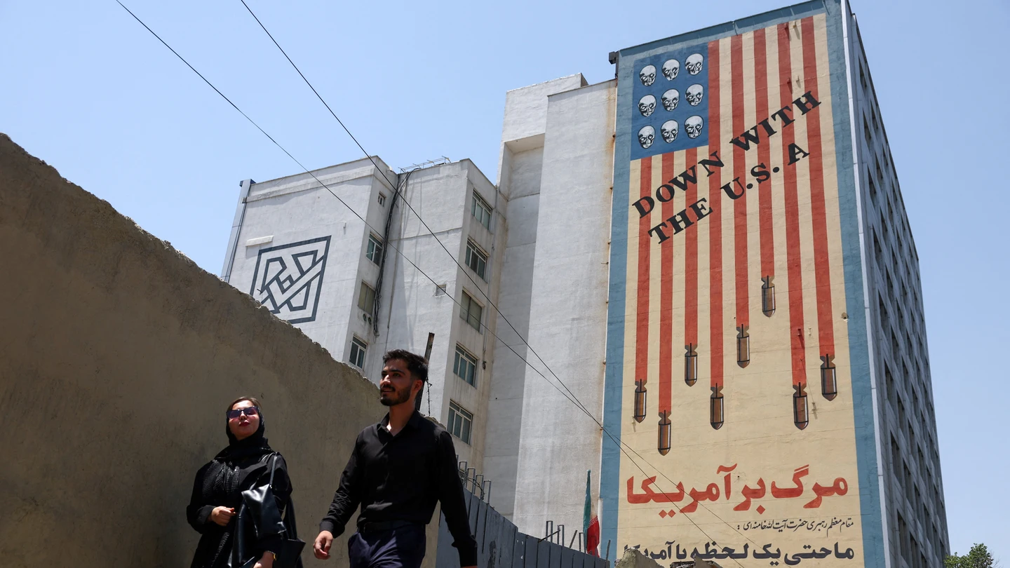 Personas caminan cerca de un mural anti-estadounidense en Teherán, Irán Personas caminan cerca de un mural anti-estadounidense en Teherán, Irán