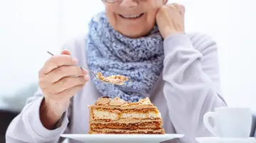 Persona mayor comiéndose una tarta Persona mayor comiéndose una tarta
