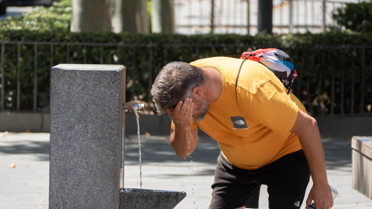 Un hombre se refresca en una fuente pública en el centro de Sevilla Un hombre se refresca en una fuente pública en el centro de Sevilla