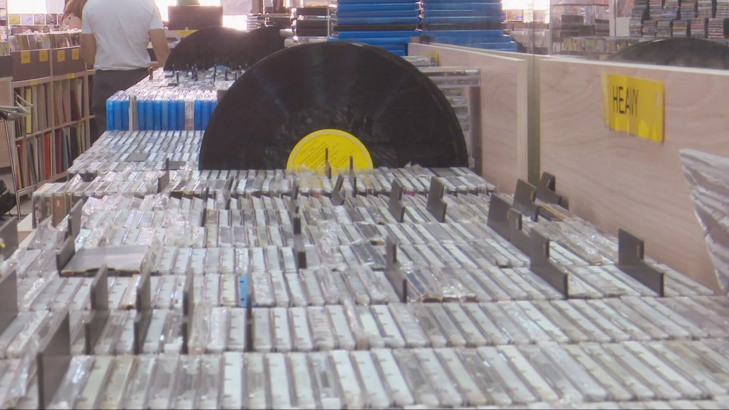 Un vinilo y varios CDs en un expositor de una tienda Un vinilo y varios CDs en un expositor de una tienda