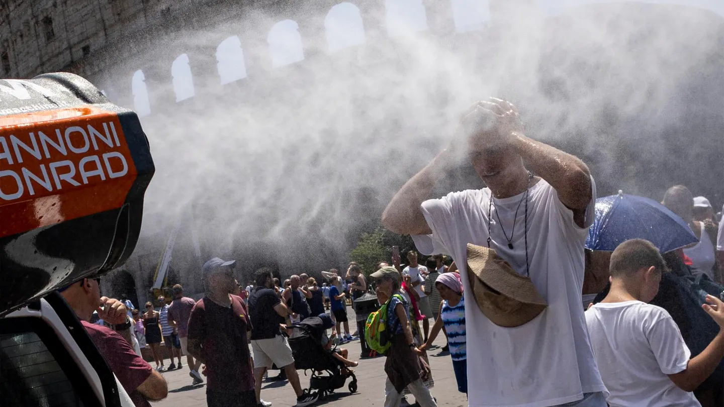 Los visitantes se refrescan entre nebulizadores de agua instalados cerca del Coliseo en Roma Los visitantes se refrescan entre nebulizadores de agua instalados cerca del Coliseo en Roma