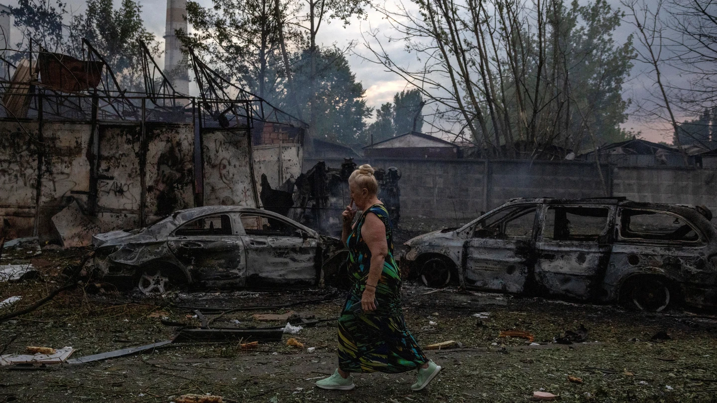 Una mujer camina cerca del lugar de un impacto que incendió varios vehículos durante ataques rusos con misiles y drones en Kyiv. Una mujer camina cerca del lugar de un impacto que incendió varios vehículos durante ataques rusos con misiles y drones en Kyiv, Ucrania, el 6 de julio de 2026.