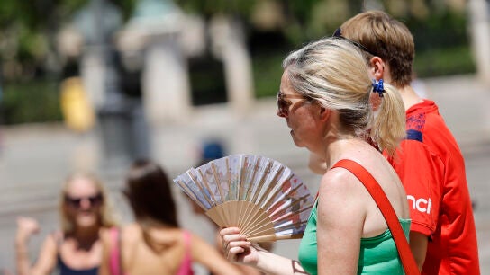 Una mujer se abanica en las calles de Valencia.