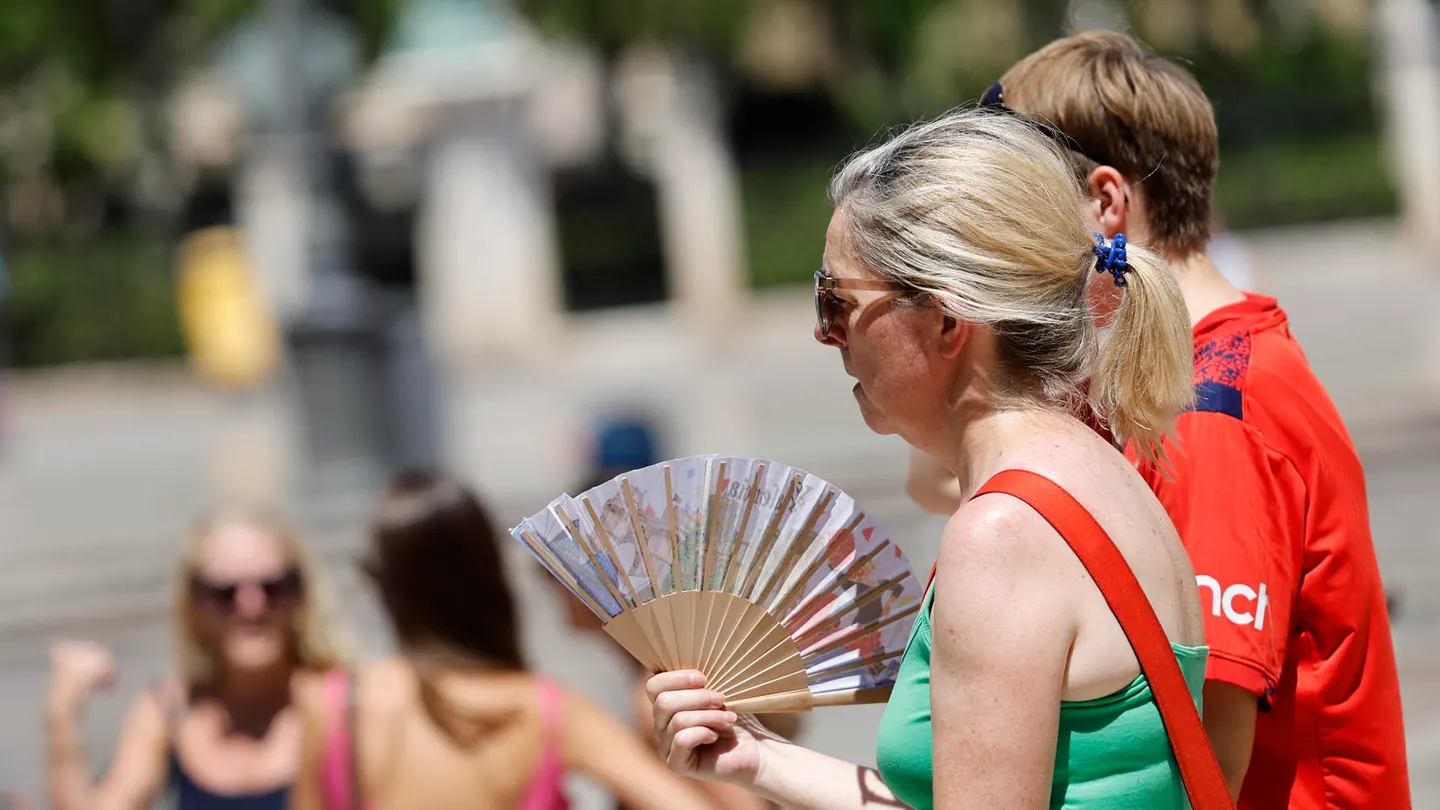 Una mujer se abanica en las calles de Valencia. Una mujer se abanica en las calles de Valencia.