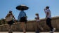 Los turistas se protegen del sol con paraguas y se hidratan este mi&eacute;rcoles en Toledo.