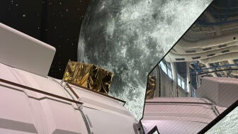 Vista de un m&oacute;dulo para el viaje espacial de la Agencia Espacial Europea expuesto frente a un panel que replica la Luna en la Ciudad de las Ciencias y la Industria de Par&iacute;s 