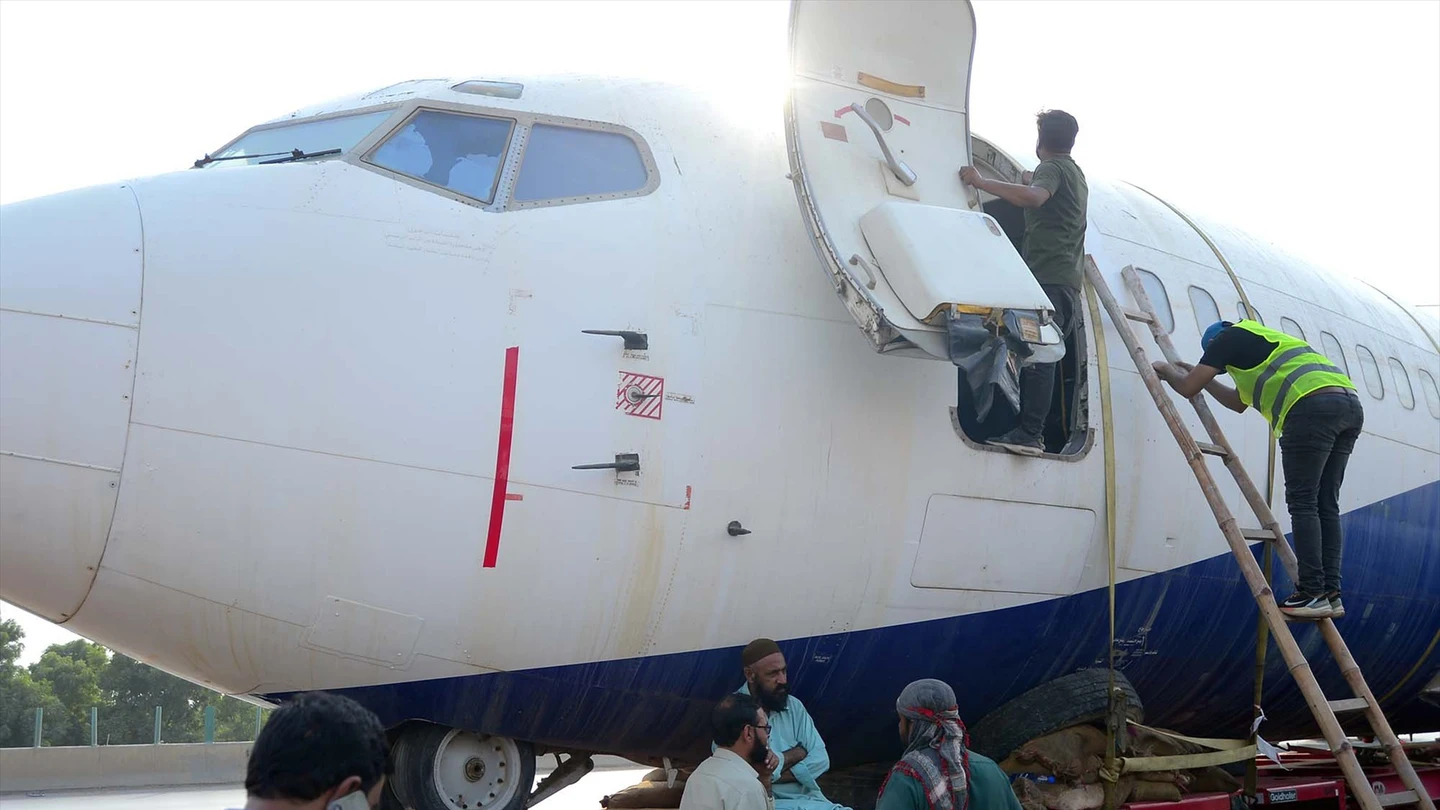 Imagen de archivo. Operarios del aeropuerto de Karachi (Pakistán) trabajan en el traslado de un Boeing 737 por carretera Imagen de archivo. Operarios del aeropuerto de Karachi (Pakistán) trabajan en el traslado de un Boeing 737 por carretera