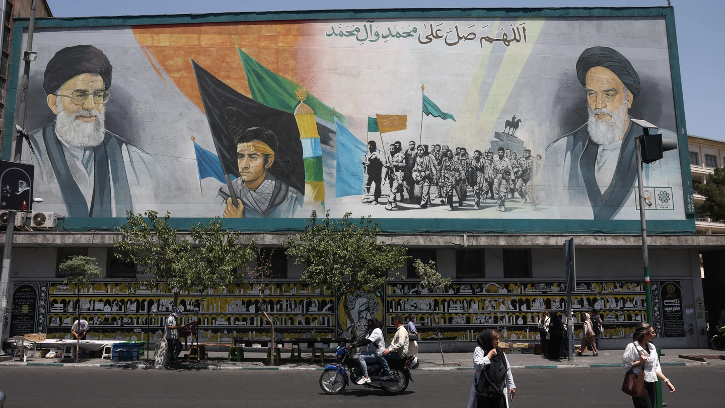 Personas caminan junto a un mural con el ayatolá Ruhollah Khomeini y Ali Jamenei, en una calle de Teherán, Irán Personas caminan junto a un mural con el ayatolá Ruhollah Khomeini y Ali Jamenei, en una calle de Teherán, Irán