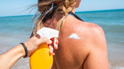 Chica dándose crema en la playa