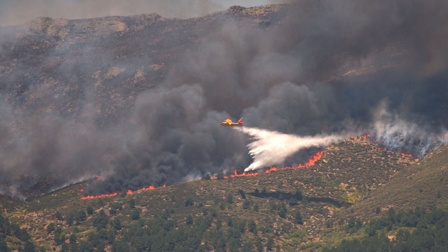 Un hidroavi&oacute;n arroja agua sobre el fuego mientras un incendio forestal avanza cerca de La Adrada, provincia de &Aacute;vila, Espa&ntilde;a