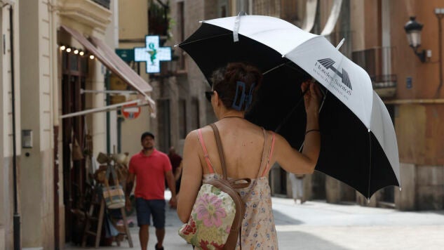 Una mujer se protege del sol con un paraguas en Valencia.