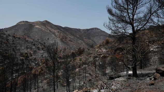  Vista general de la zona quemada en La Vall d'Uix&oacute; (Castell&oacute;n) durante la quinta jornada de lucha contra el fuego.