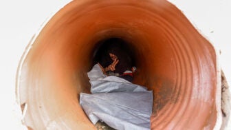 Un migrante se esconde en un t&uacute;nel de playa para evitar a los soldados espa&ntilde;oles tras los cruces masivos