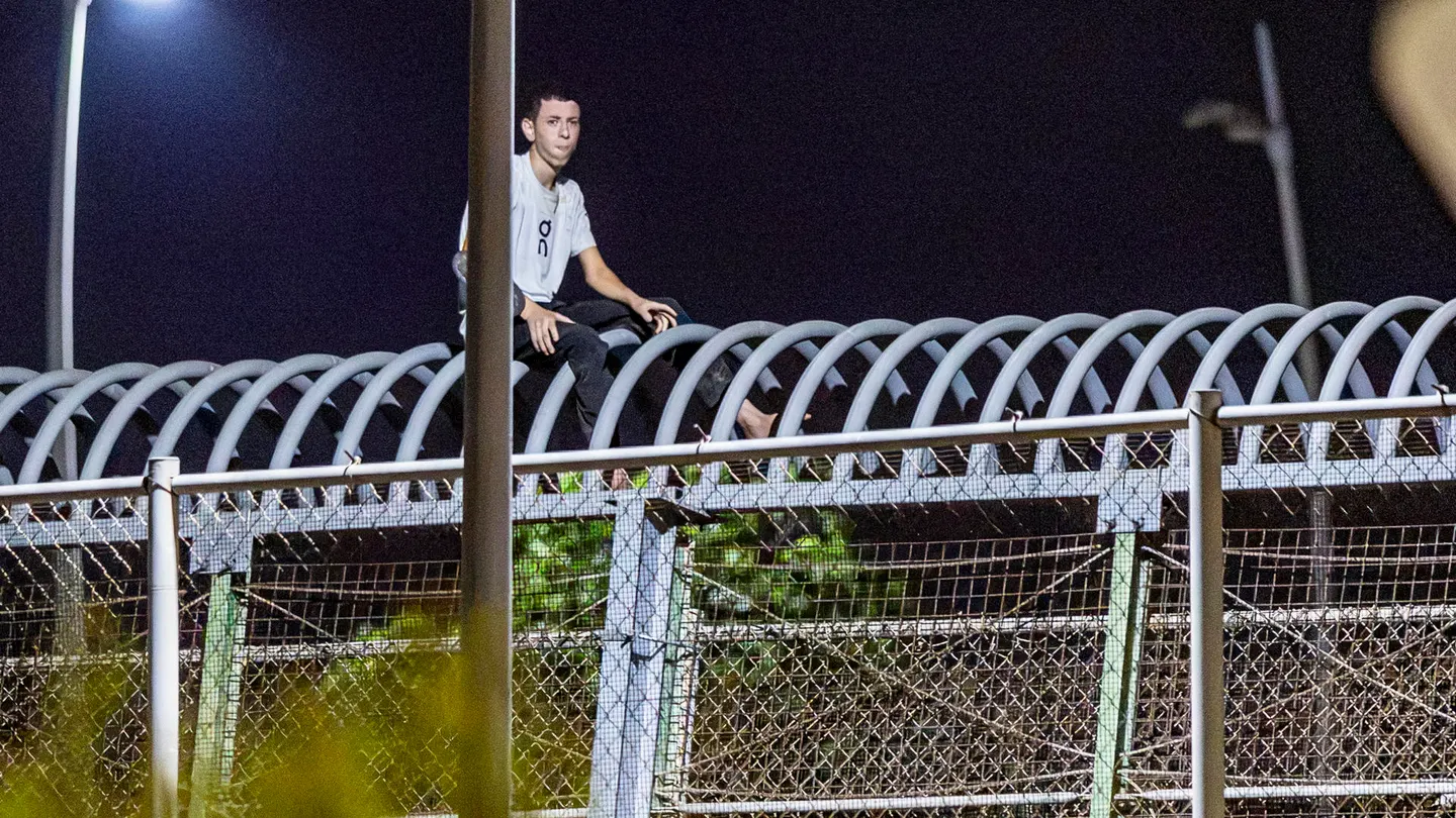 Imagen de un joven magrebí en la valla de Melilla Imagen de un joven magrebí en la valla de Melilla