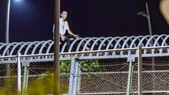 Imagen de un joven magreb&iacute; en la valla de Melilla