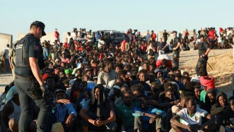 Migrantes hacen fila para recibir alimentos y bebidas de la Cruz Roja, tras los cruces masivos de migrantes en Ceuta