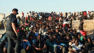 Migrantes hacen fila para recibir alimentos y bebidas de la Cruz Roja, tras los cruces masivos de migrantes en Ceuta