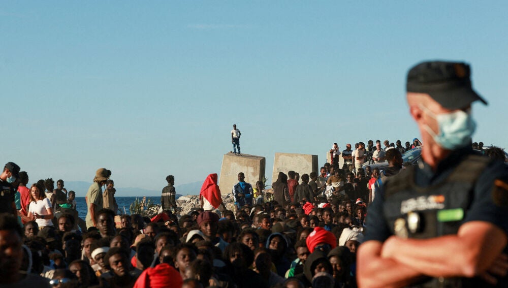 Migrantes hacen fila para recibir alimentos y bebidas de la Cruz Roja, tras los cruces masivos de migrantes en Ceuta