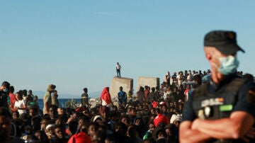 Migrantes hacen fila para recibir alimentos y bebidas de la Cruz Roja, tras los cruces masivos de migrantes en Ceuta