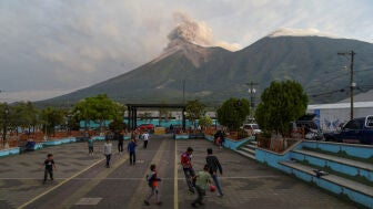 Unos ni&ntilde;os jugando a la pelota en San Juan Alotenango (Guatemala), con el volc&aacute;n de Fuego al fondo