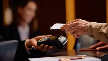 Hombre pagando en la recepción de un hotel Hombre pagando en la recepción de un hotel