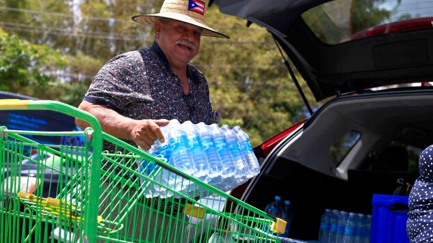 Una persona transporta botellas de agua para enfrentar el racionamiento impuesto, este jueves en Trujillo Alto (Puerto Rico).