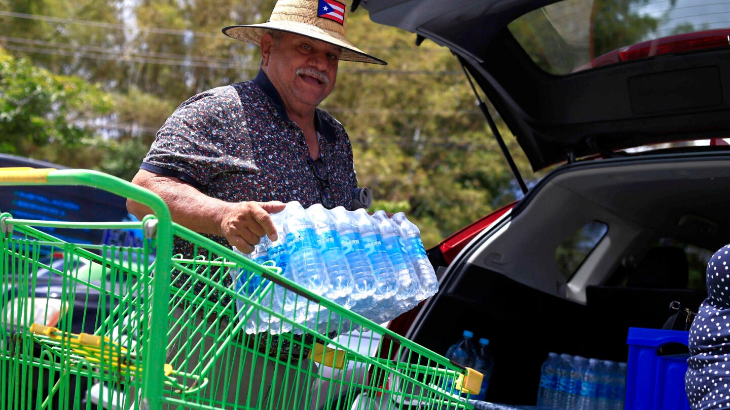 Una persona transporta botellas de agua para enfrentar el racionamiento impuesto, este jueves en Trujillo Alto (Puerto Rico).