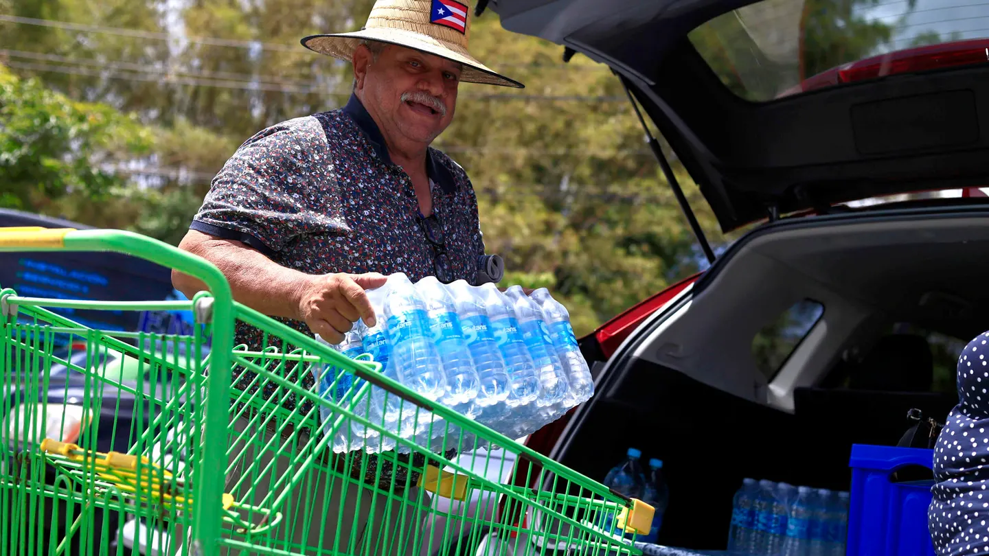 Una persona transporta botellas de agua para enfrentar el racionamiento impuesto, este jueves en Trujillo Alto (Puerto Rico). Una persona transporta botellas de agua para enfrentar el racionamiento impuesto, este jueves en Trujillo Alto (Puerto Rico).