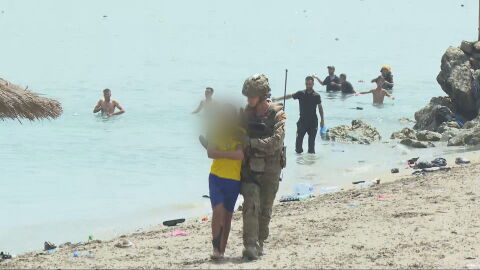 Un militar acompa&ntilde;a a un menor que ha llegado a Ceuta