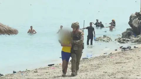 Un militar acompaña a un menor que ha llegado a Ceuta Un militar acompaña a un menor que ha llegado a Ceuta