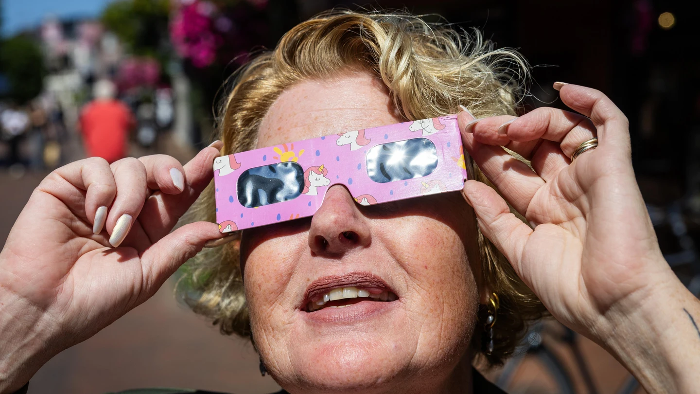 Una mujer prueba unas gafas para el eclipse Una mujer prueba unas gafas para el eclipse