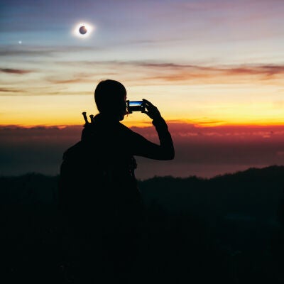 Mujer fotografiando el eclipse solar
