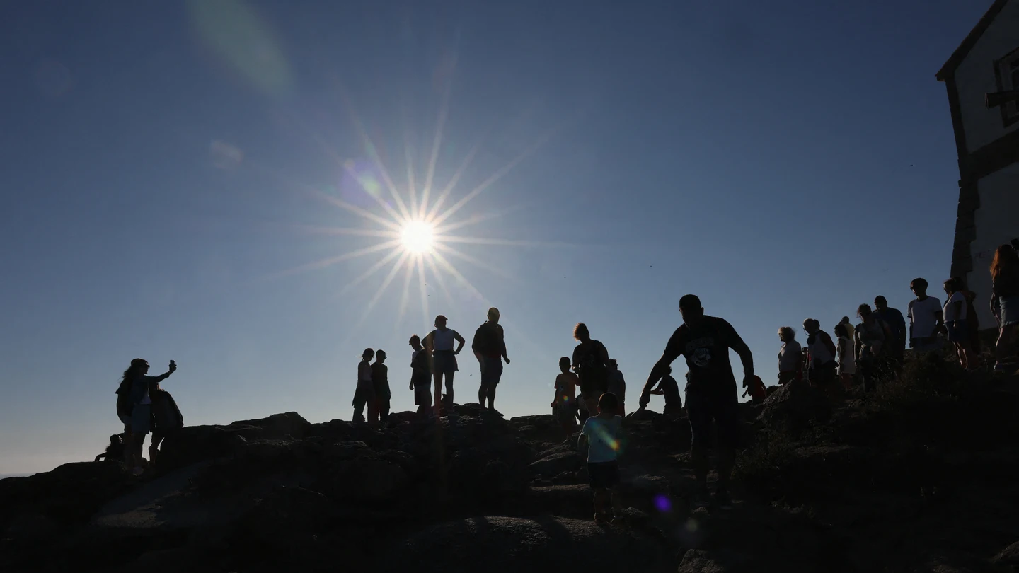 Turistas caminan por el cabo Fisterra el día antes del eclipse solar, en la Costa de la Muerte Turistas caminan por el cabo Fisterra el día antes del eclipse solar, en la Costa de la Muerte