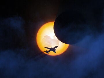 Avi&oacute;n volando sobre un eclipse solar