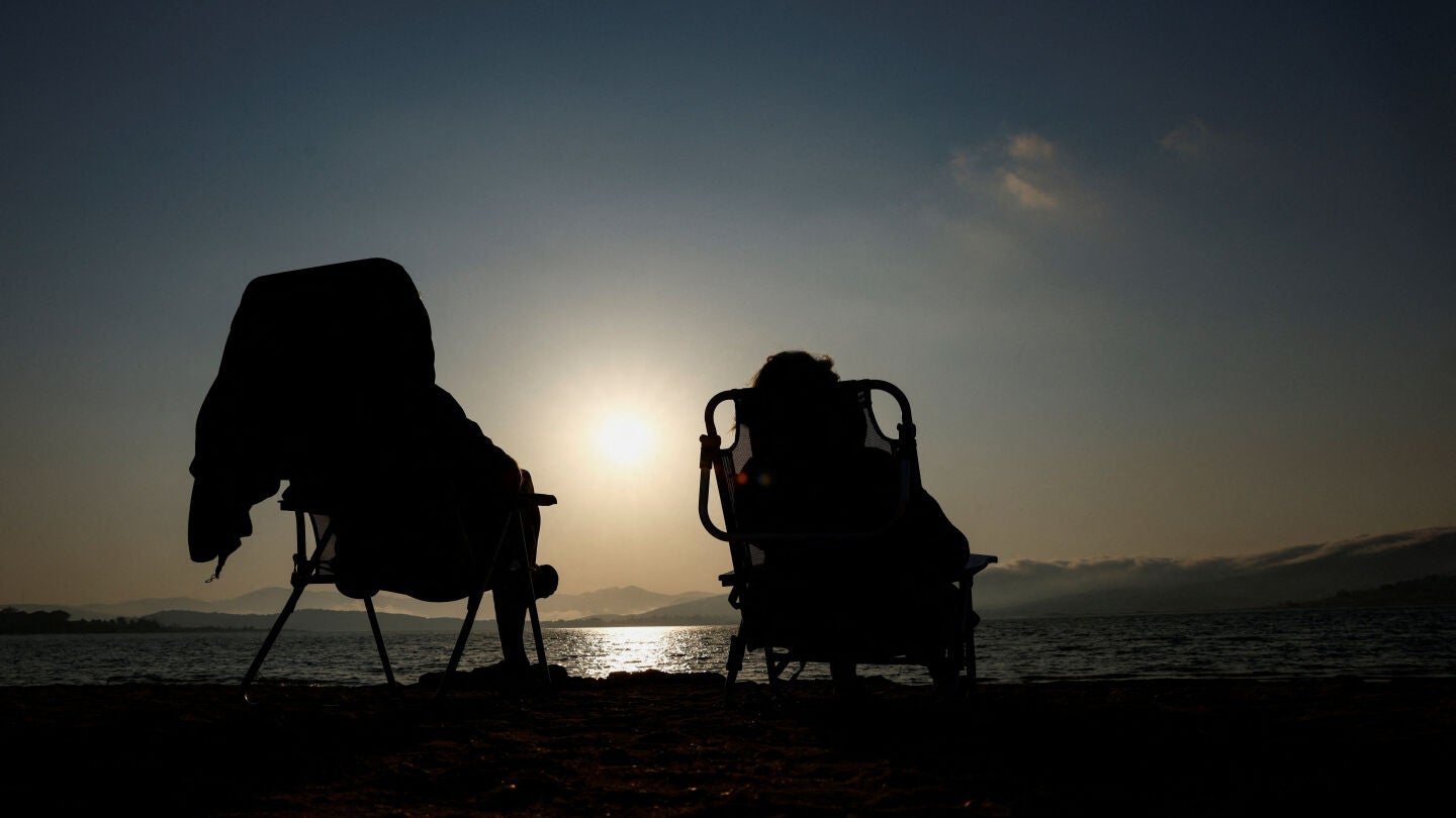 Dos personas miran al Sol en la jornada previa al eclipse solar en Espa&ntilde;a