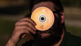 Hombre usa un CD para ver el eclipse