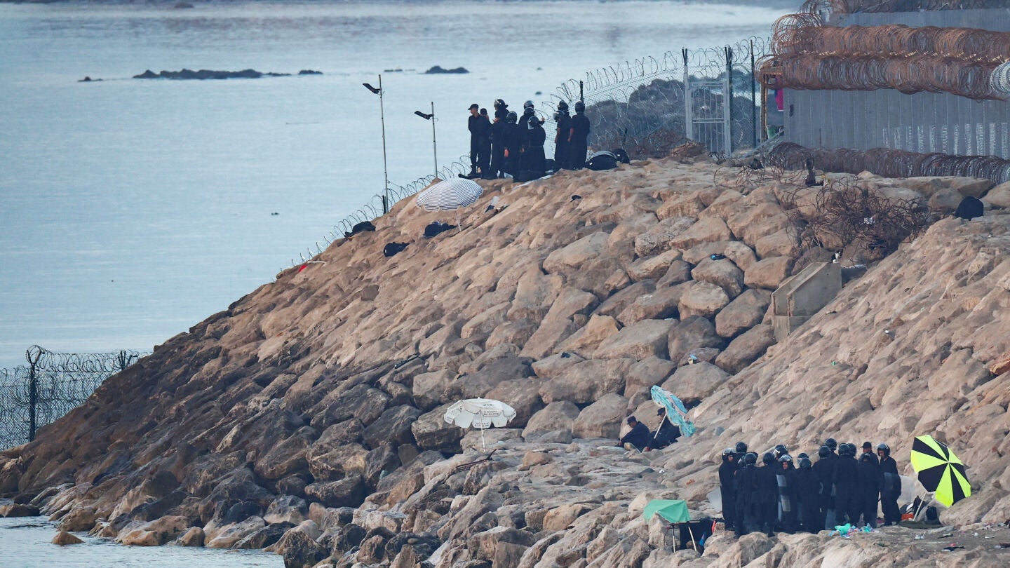 Personal de seguridad marroqu&iacute; custodia la playa en la frontera con Espa&ntilde;a en Ceuta, tras el cruce masivo de migrantes a pie y por mar desde Marruecos hacia territorio espa&ntilde;ol, vista desde Ceuta