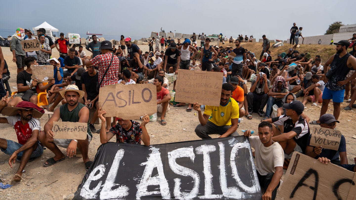 Un grupo de migrantes concentrados para solicitar asilo en la playa del trampol&iacute;n de Ceuta