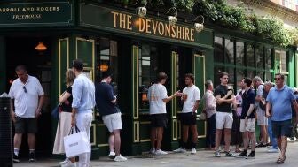 Gente bebiendo a las puertas de un pub ingl&eacute;s