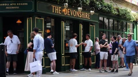 Gente bebiendo a las puertas de un pub ingl&eacute;s
