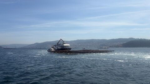 Barco recogiendo mejillón en una batea de la ría de Vigo