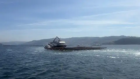 Barco recogiendo mejillón en una batea de la ría de Vigo Barco recogiendo mejillón en una batea de la ría de Vigo
