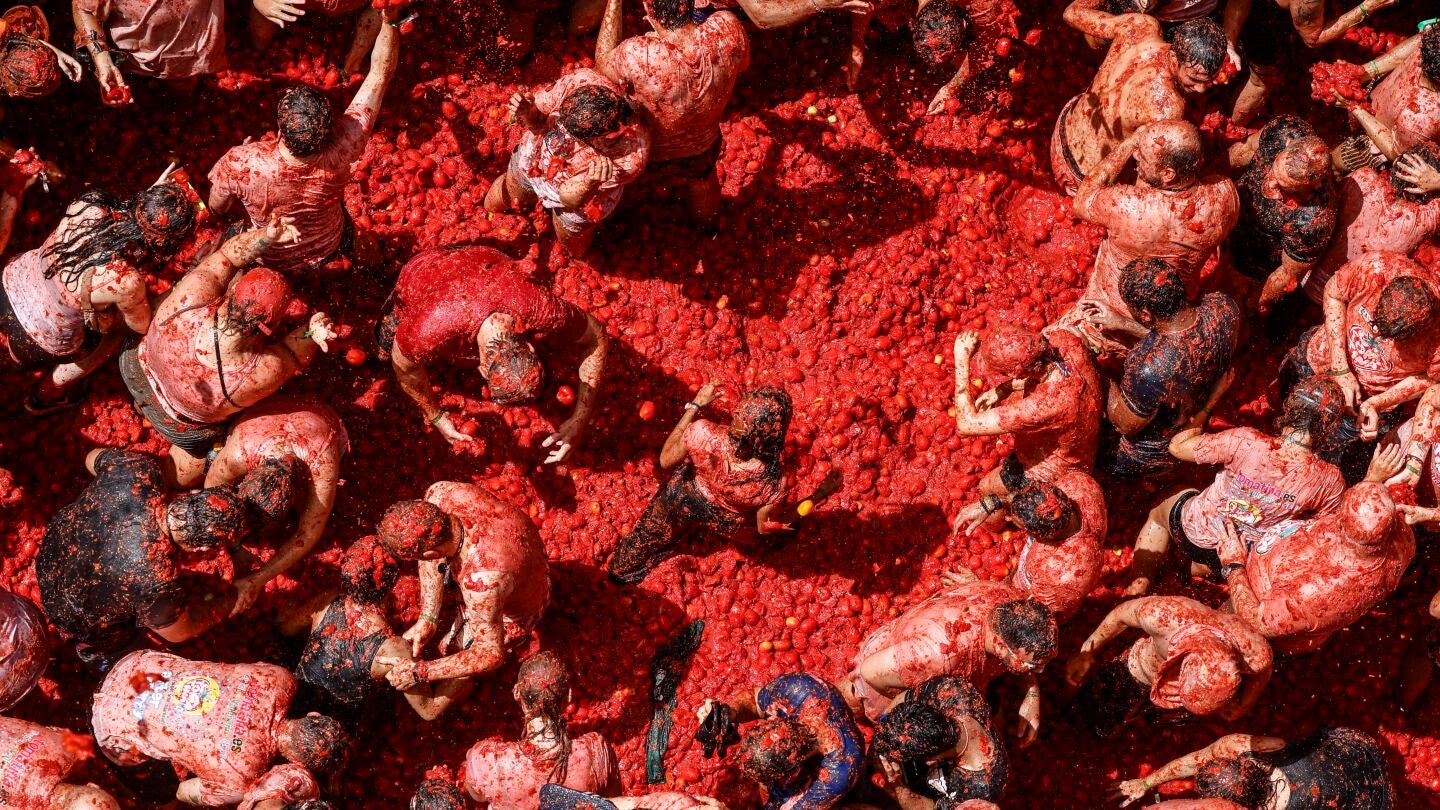 Varios participantes de la fiesta de la Tomatina de Bu&ntilde;ol festejan durante el evento, a 26 de agosto de 2026, en Bu&ntilde;ol, Valencia, Comunidad Valenciana (Espa&ntilde;a).